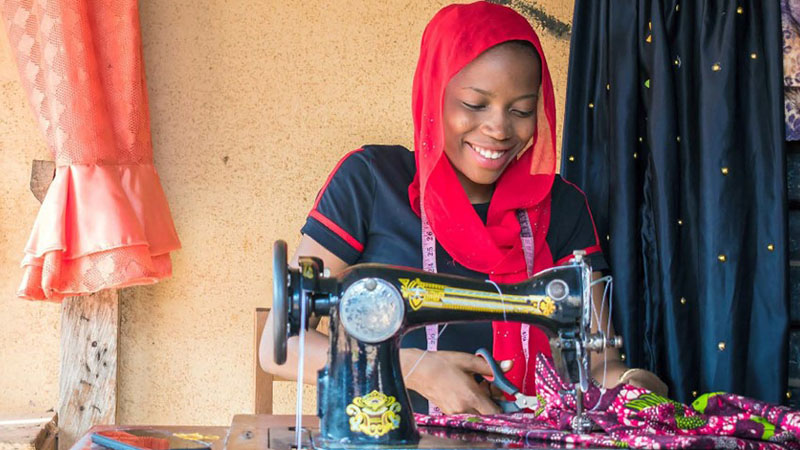 Mujer cosiendo ropa con una máquina de coser